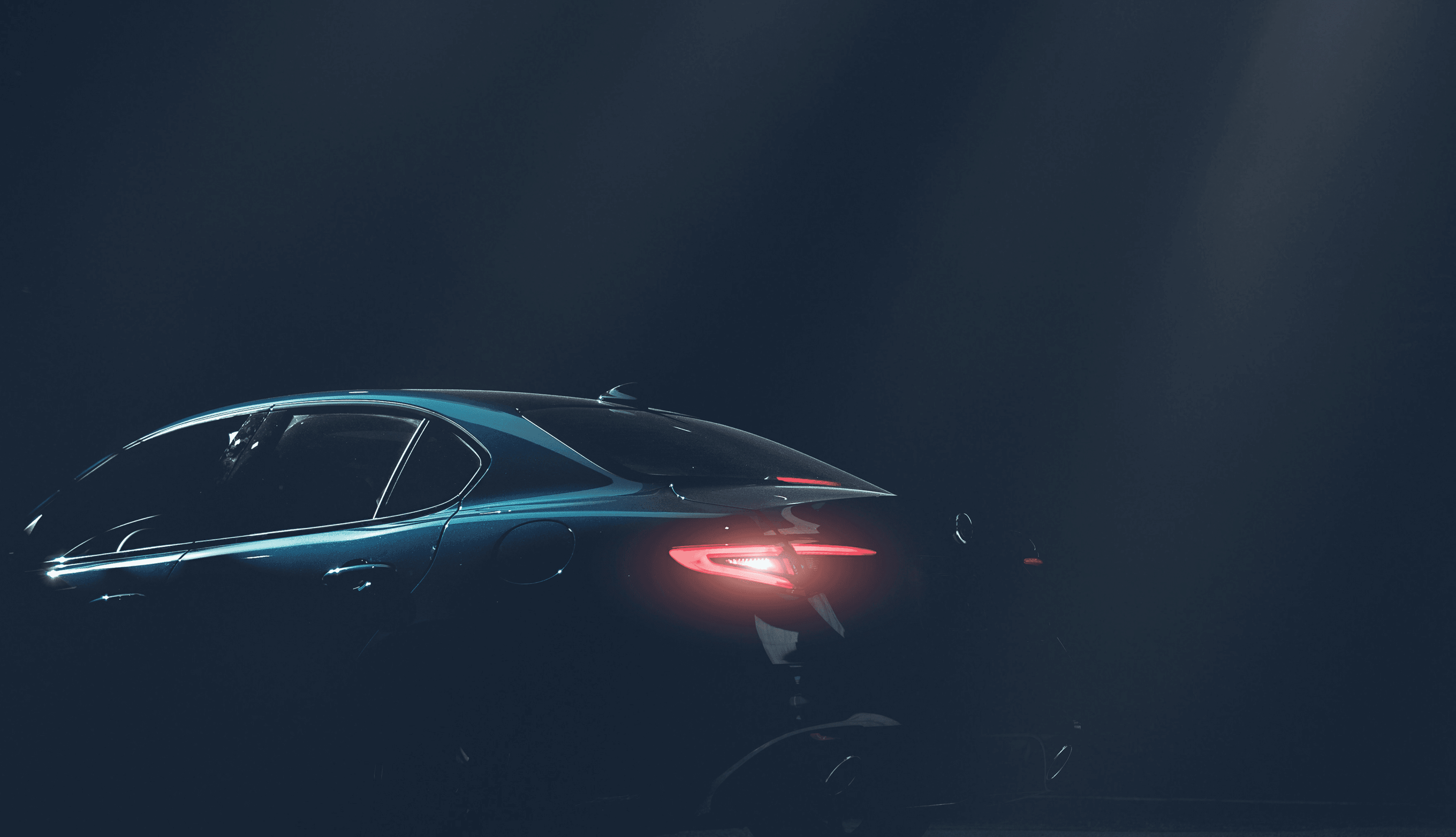 Dark luxury car silhouette with glowing taillights